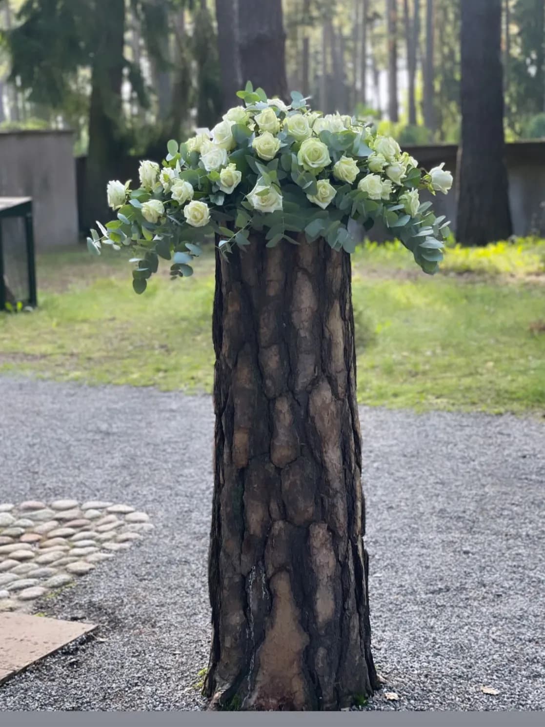 Kistdekoration med vita rosor och eukalyptus, fotograferad på skogskyrkogården